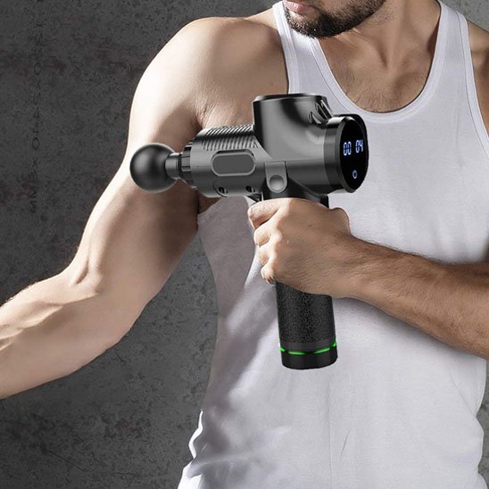 Pistolet de massage tenu par homme en camisole sur biceps