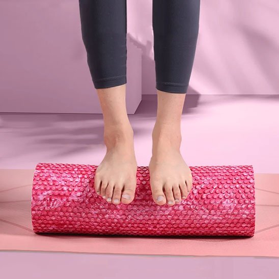Rouleau de massage rose sous les pieds